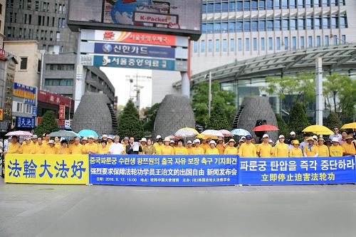 '八月十二日下午三點，韓國部份法輪功學員在中共大使館前舉行集會，敦促中共當局重新頒發護照，還給王治文自由，使其與家人團聚。'