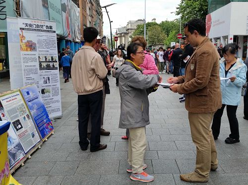 圖1-2：七月三十日，愛爾蘭學員在都柏林的格拉夫頓大街上傳播法輪功的真相，民眾了解中共的罪惡後，聯署舉報迫害法輪功的元凶江澤民。