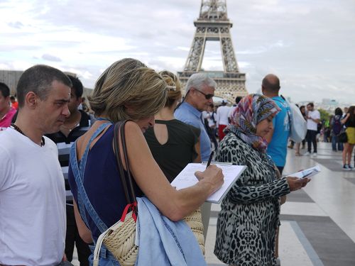 圖1-4：二零一六年九月十一日下午，法輪功學員在巴黎鐵塔下的人權廣場，進行講真相和徵簽活動。許多遊客駐足了解真相，並簽名支持法輪功學員反迫害。
