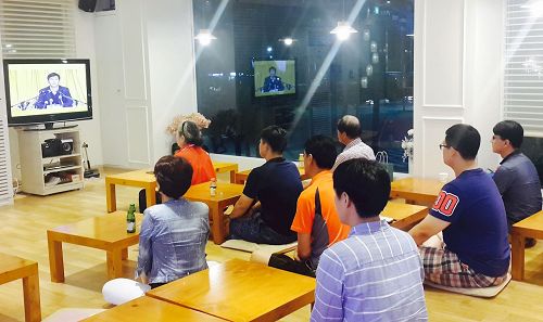 '圖：新入門的學員在首爾天梯書店三樓觀看法輪功創始人李洪志先生的講法錄像'