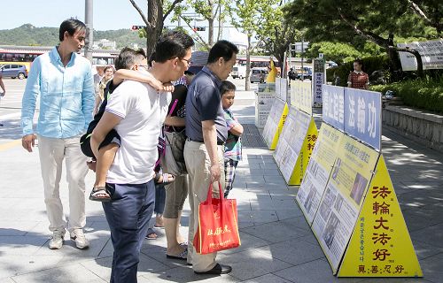 「圖1-3：首爾社稷公園中的中國大陸遊客觀看法輪功真相展板」