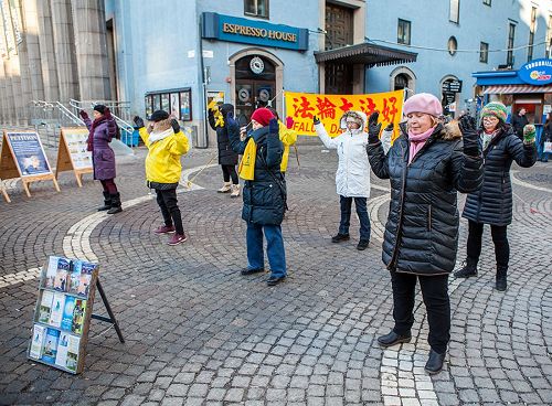'圖3：在斯德哥爾摩繁華的鬧市區（Hötorget）法輪功學員舉辦弘法講真相活動，法輪功學員向民眾演示功法，'