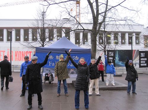 '圖1：法輪功學員在芬蘭首都市中心舉辦弘法活動，圖為學員們在集體煉功'