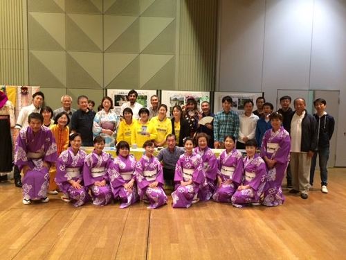 '圖1：稻澤市民會館的六鹿（Mr. Mutsuga）館長與部份參加本次活動的團體人員法輪功展位前合影留念。'