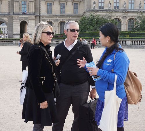 '圖4：遊行在盧浮宮廣場結束後，這對夫婦仍在向法輪功學員詢問真相。'