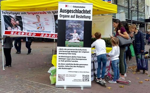'圖1～4：二零一七年十月二十一日，德國烏爾姆法輪功學員在市內步行街舉辦活動，圖為民眾簽名聲援法輪功學員。'