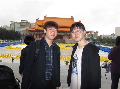 圖3：韓國青年黃柄國（右）偕同友人來台旅遊，對於學煉法輪功表示興趣。