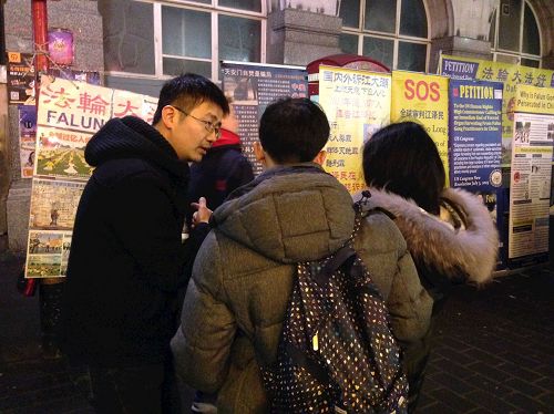 '圖2：二零一七年中國新年期間，一對華人青年在倫敦唐人街向法輪功學員了解真相並選擇三退'