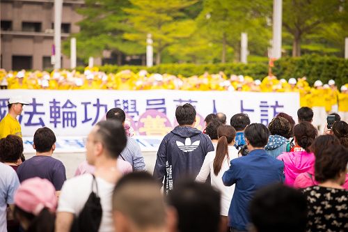 圖6-7：法輪功學員在台北市政府前的市民廣場舉行紀念四二五活動。經過的大陸遊客、市民駐足觀看，並拿起手機拍照。