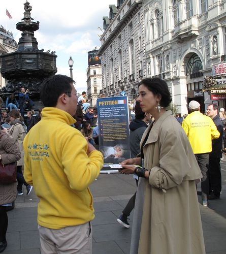 '圖18：二零一七年四月二十二日，英國女士碧麗在皮卡迪利廣場第一次聽聞法輪功，簽名反迫害，並表示有興趣'