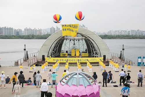 '圖1：5月13日，韓國部份法輪功學員和市民們匯聚在汝矣島漢江公園，歡慶第18屆「世界法輪大法日」及法輪大法洪傳25週年。'