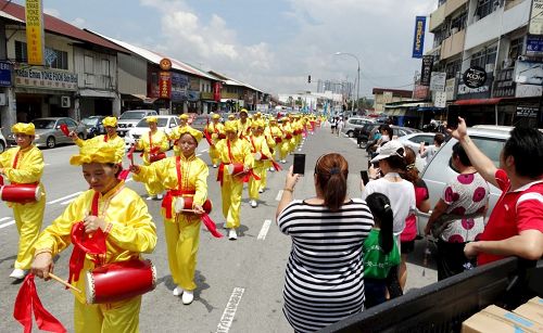 '圖1～4：陣容壯觀的法輪功遊行隊伍，在沙登新村（Seri Kembangan）浩蕩出發，歡慶世界法輪大法日，受到民眾的歡迎。'
