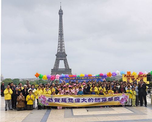 '圖1：法國部份法輪功學員聚集在艾菲爾鐵塔下的人權廣場，慶祝法輪大法洪傳世界二十五週年，同時向法輪功創始人李洪志先生恭祝生日快樂。'