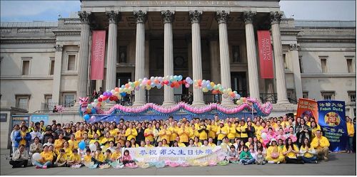 '圖1：二零一七年五月七日，參加慶祝「5﹒13世界法輪大法日」的英國法輪功學員在倫敦特拉法加廣場（Trafalgar Square）集體合影「恭祝師父生日快樂！」'