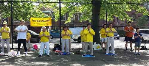 '圖1：二零一七年六月十一日，紐約部份法輪功學員來到布魯克林第三華人社區，向當地民眾介紹法輪功。圖為法輪功學員向過往民眾展示法輪功功法。'