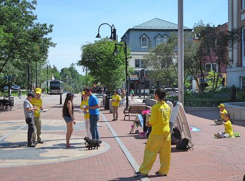 '圖7：法輪功學員在佛蒙特州伯靈頓市街區給遊人講法輪功真相。'