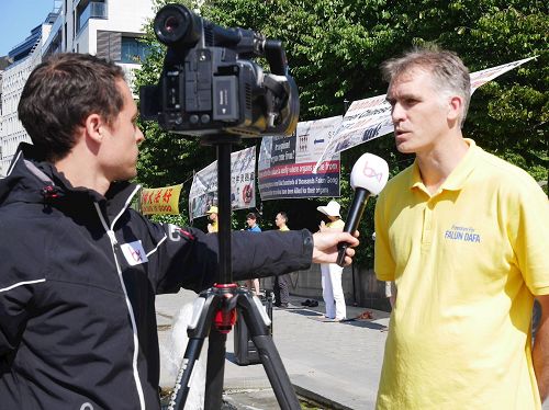 '圖3：比利時媒體布魯塞爾電視台記者現場採訪法輪功學員Nico'