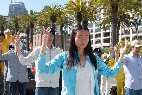 '圖1～2：二零一七年七月十五日一早，舊金山灣區的法輪功學員來的舊金山旅遊景點之一的渡輪廣場集體煉功，並告訴民眾法輪功的真相。'