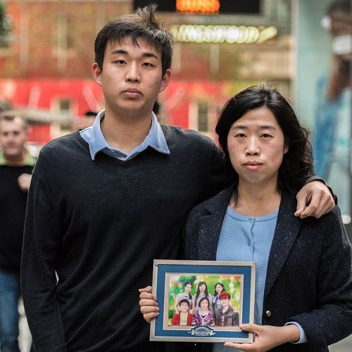 '圖1：法輪功學員劉玲（右）拿著全家福照片和姪子賈明真'