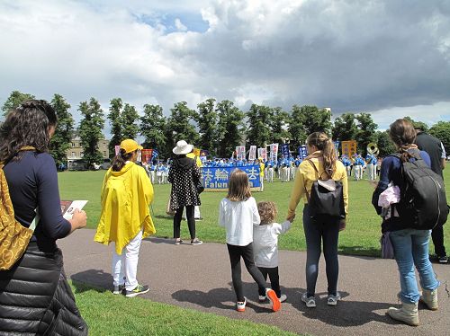 '圖1：在劍橋帕克公園，法輪功學員的遊行隊伍開始前，天國樂團的排練吸引了民眾'