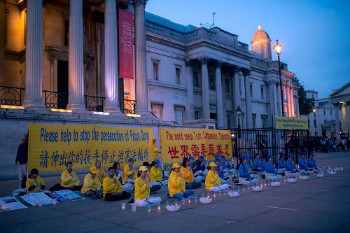 '圖1～2：二零一七年七月二十三日，英國法輪功學員在倫敦特拉法加廣場（又名鴿子廣場）燭光守夜，呼籲世人攜手制止中共迫害法輪功。'