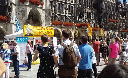 '圖1：二零一七年七月二十九日，德國法輪功學員在慕尼黑市政廳前瑪琳廣場舉辦活動，介紹法輪功，揭露中共迫害。'