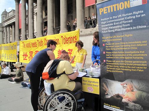 '圖20：坐在輪椅上的倫敦女士和朋友簽名反迫害'