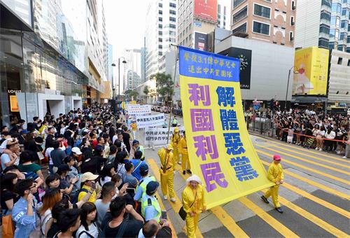 '圖11：法輪功學員遊行，聲援三億多中華兒女退出中共黨、團、隊。'