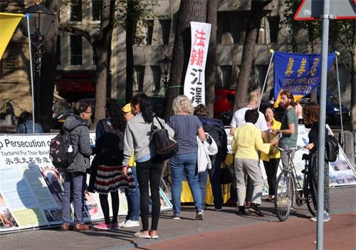 '圖1～2：荷蘭法輪功學員在海牙舉辦活動，揭露中共迫害，路人紛紛駐足了解詳情。'