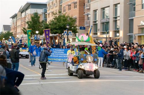 '圖3：青年法輪功學員參加德州大學阿靈頓分校返校日遊行受歡迎。'
