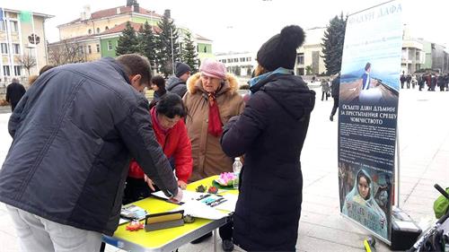 '圖3：民眾在要求法辦江澤民的徵簽表上簽名'
