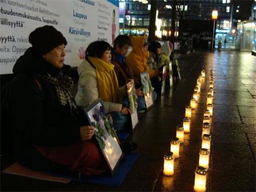 '圖1-2：芬蘭法輪功學員在首都赫爾辛基市中心點起燭光，悼念被中共迫害致死的中國大陸同修'