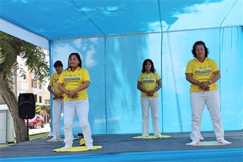 '圖1～3：秘魯法輪功學員應馬格達萊納區政府邀請參加中老年健康展。圖為，法輪功學員在健康展中心舞台介紹和演示法輪功功法。'