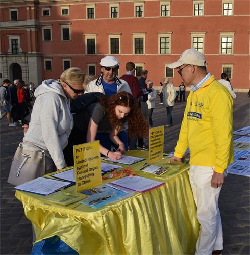 '圖4～5：華沙古城廣場眾多遊客簽名反對中共活摘器官的邪惡行徑'