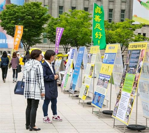 '圖10：2018年5月13日，首爾市中心廣場舉行5﹒13「世界法輪大法日」慶典，路人駐足觀看展板。'