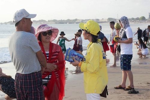 圖7：法輪功學員在著名景點格東岸（Kedongan）海灘向遊客講真相