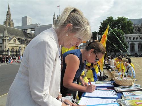 '圖10：兩位英格蘭女士簽字支持法輪功學員反迫害'