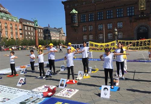 '圖2：夏令營的孩子們週六下午參加哥本哈根市政廳廣場的七﹒二零反迫害活動，展示法輪功五套功法'