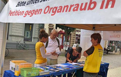 '圖1～4：二零一八年七月七日，德國法輪功學員在西南邊陲Lörrach市舉辦了傳播法輪功真相信息日。不少民眾駐足了解真相，簽名支持制止活摘。'
