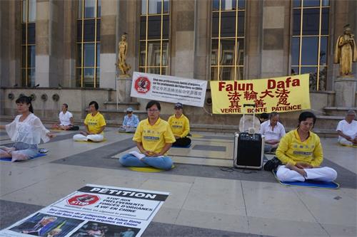 '圖5：8月19日，巴黎部份法輪功學員在人權廣場上煉習第五套功法'