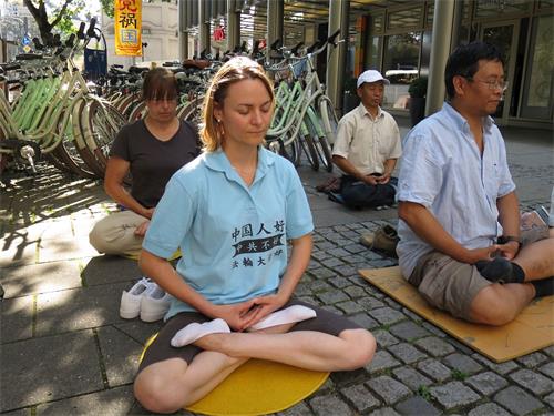 '圖4：法輪功學員Iris（前排左）的T恤衫上寫著：「中國人好，中共不好，法輪大法好」，她來慕尼黑給中國遊客講真相。'