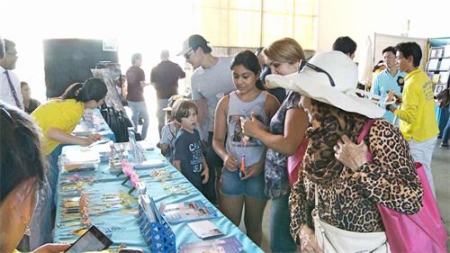 '圖3～4：二零一八年九月二十二日，法輪功學員在第十七屆「爾灣全球村文化節」設立了展位，許多民眾前來了解。'