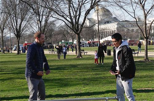 '圖2：一位年輕的遊客（右）在國家廣場學煉法輪功。'