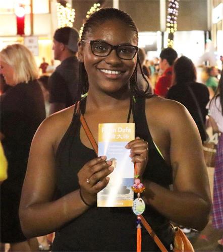 '圖3：非裔女孩Nia Liberty手持法輪功傳單，表示一定會回去好好閱讀。'
