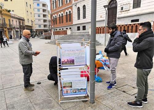 '圖1：二零一九年一月十三日，意大利撒丁島的法輪功學員在卡利亞里市（Cagliari）設立真相點傳播法輪功的真相。不少路人駐足了解真相。'