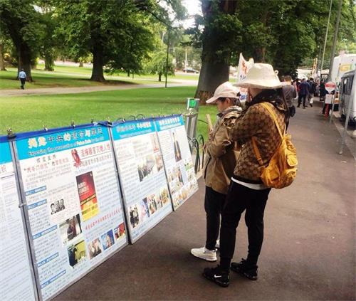 墨爾本市中心著名景點費茨羅伊公園是大陸遊客了解法輪功真相的窗口。圖為中國新年期間，大陸客在閱讀擺放在公園入口處的大法真相展板。
