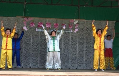 '圖5：法輪功學員在豐田市水源公園櫻花節的舞台上進行法輪功的功法展示'