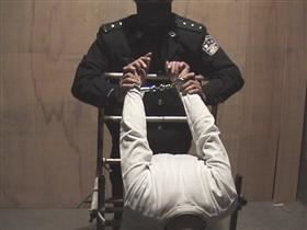 '圖2：中共酷刑示意圖：雙手反背銬在椅子上'
