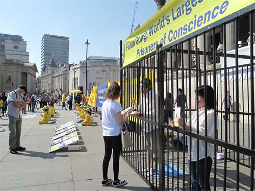 '圖1～4：二零一九年四月二十一日，英國法輪功學員在位於倫敦市中心的特拉法加廣場（Trafalgar Square）北平台集體煉功、發傳單、講真相、徵簽反迫害，紀念「四﹒二五」和平上訪二十週年。'