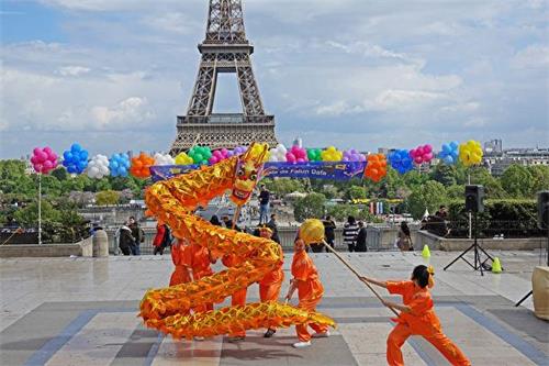 '圖6：巴黎法輪功學員慶祝法輪大法日，表演龍舞'